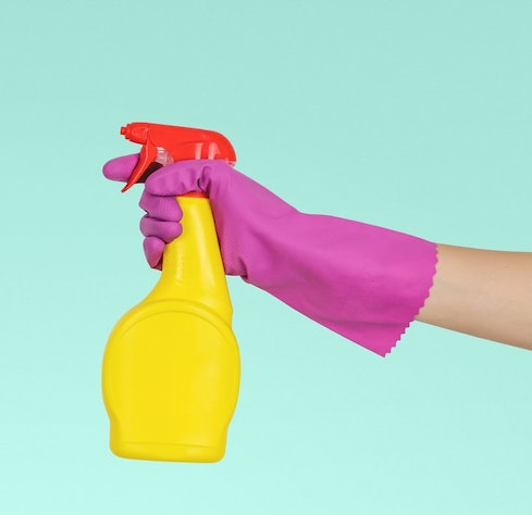 cleaning spray in gloved hand