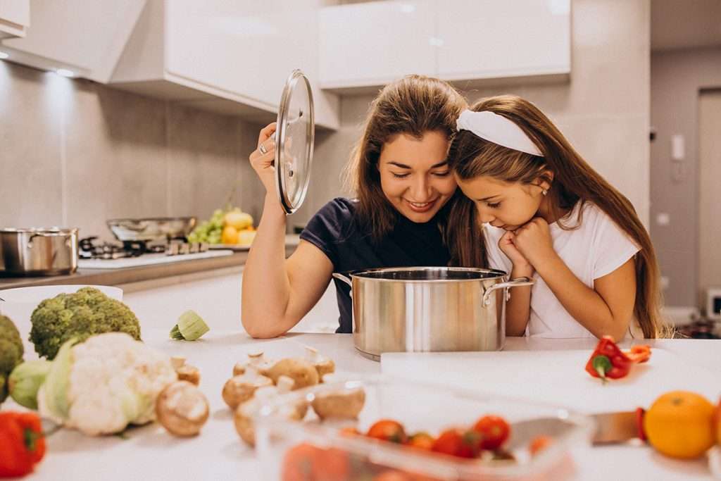 Woman and young girl enjoying cooking together
